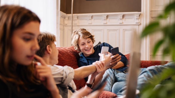 Tenåringer med mobiler i sofakroken